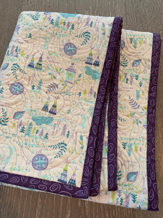 Folded handmade Bohemian Neverland adventure baby quilt with purple paisley binding