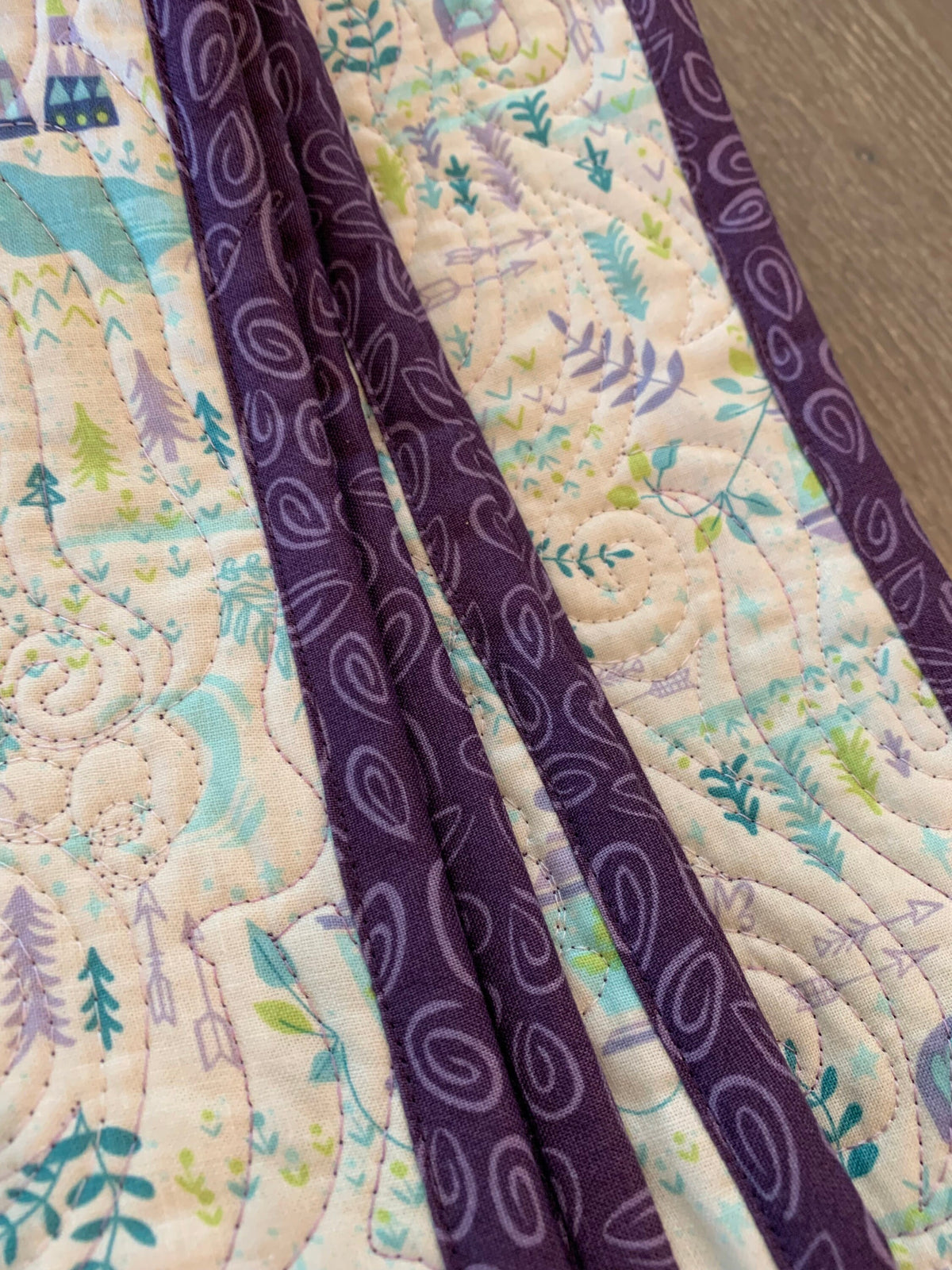 Close-up of purple paisley binding and edge-to-edge quilting on handmade baby quilt