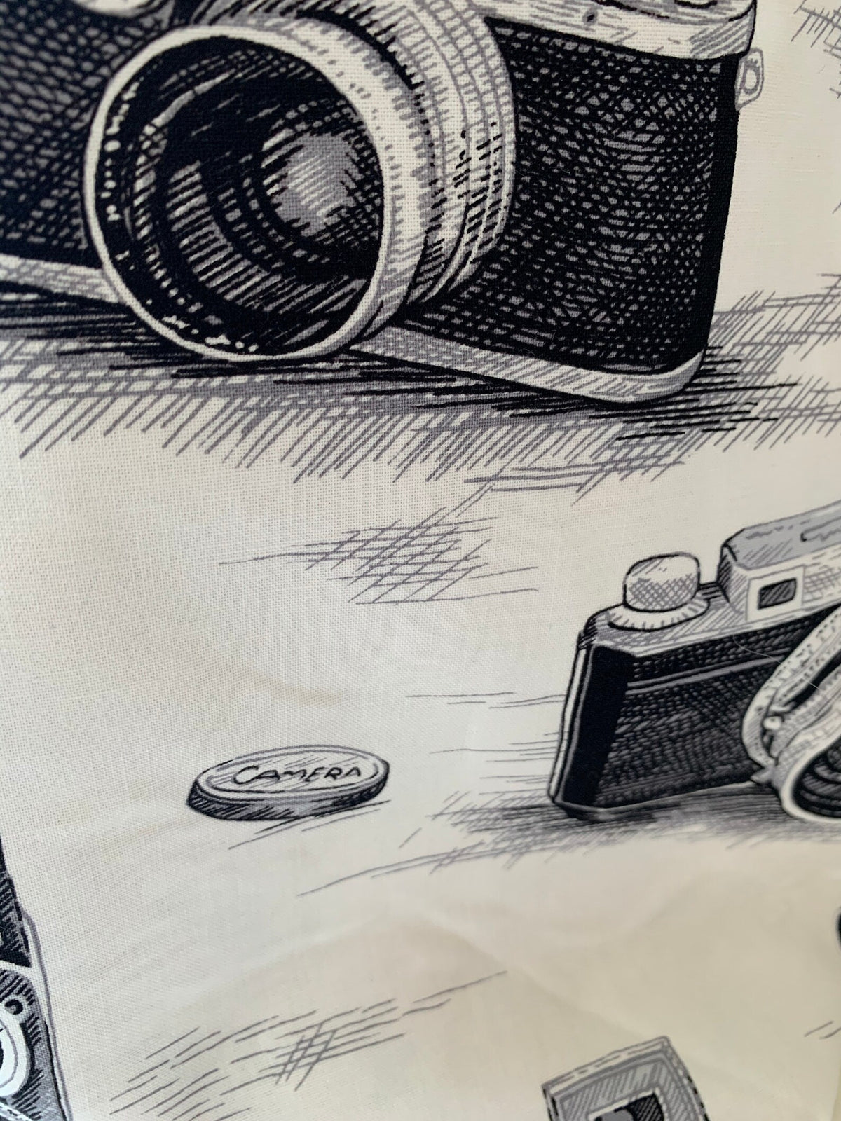 Close-up of black-and-white vintage camera illustrations on cotton bag fabric