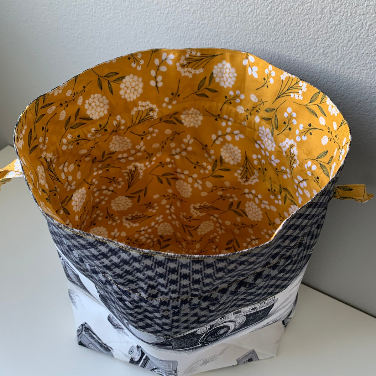 Mustard-yellow floral cotton lining inside handmade camera print drawstring bag